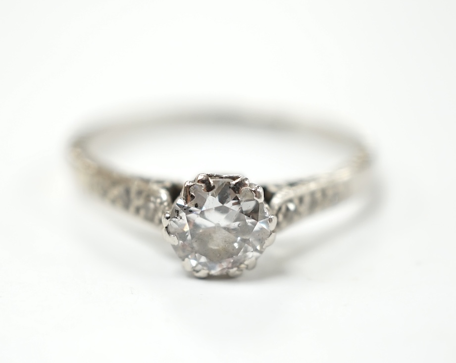 An early to mid 20th century white metal (stamped platinum) and single stone diamond set ring, with six stone diamond chip set shoulders, the stone diameter 5.5mm, depth 3mm, size N, gross weight 2.7 grams. Condition - f
